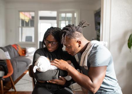 Photo of mother and father holding a young baby